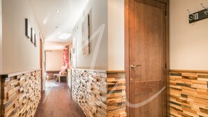 A hallway with wooden paneling on the walls and a wooden door. - Beroia (Vielha e Mijaran)