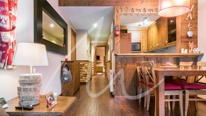 A cozy living room with a wooden floor, a dining area with a wooden table and chairs, and a kitchen with wooden cabinets. - Beroia (Vielha e Mijaran)