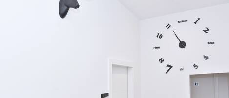 A room with a wall clock, a mounted deer head, and a door labeled '5'.