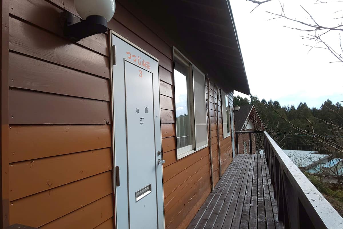 A wooden building with a door labeled "3" and a small window.