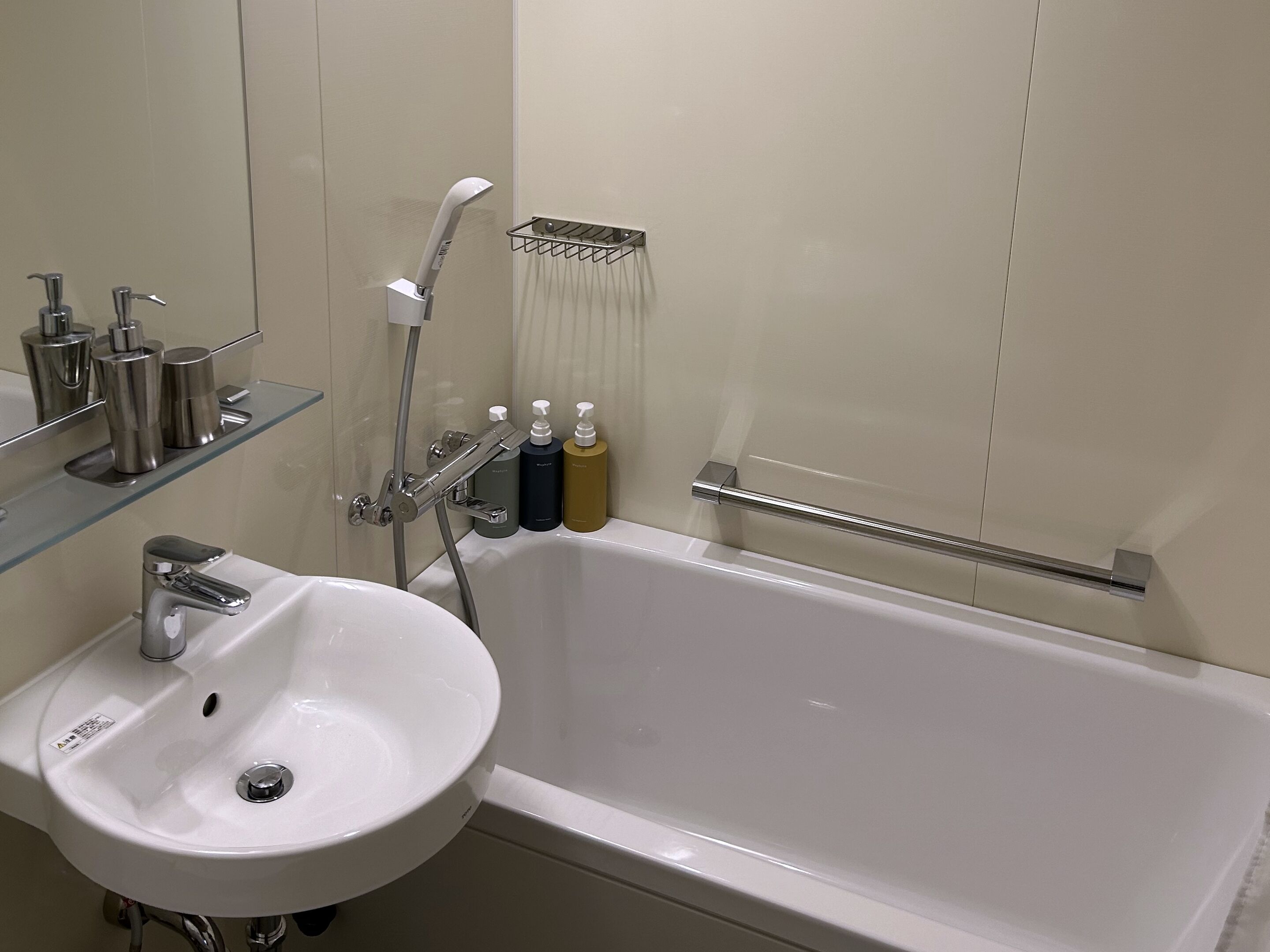 A modern bathroom with a white sink, chrome fixtures, and a glass shower enclosure.