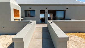 A modern building with a concrete facade, a brick fireplace, and a number '2' sign. - L'Ermitage Quagga Lodge (Bergrivier)