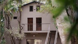 A two-story building with a balcony, a staircase, and a glass door entrance. - Kruger Eden Lodge (Nkomazi)