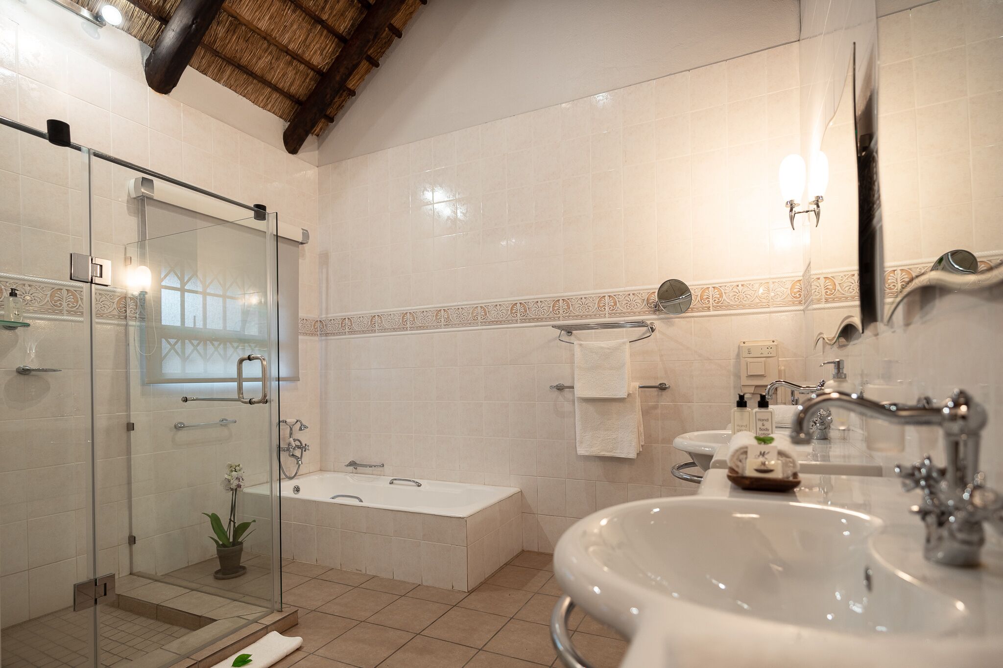 A modern bathroom with a glass-enclosed shower, a freestanding bathtub, and a large sink.