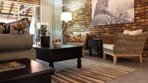 Ein gemütliches Wohnzimmer mit Backsteinwand, einem großen Kunstwerk mit Leopardenmuster und einem modernen Sofa.