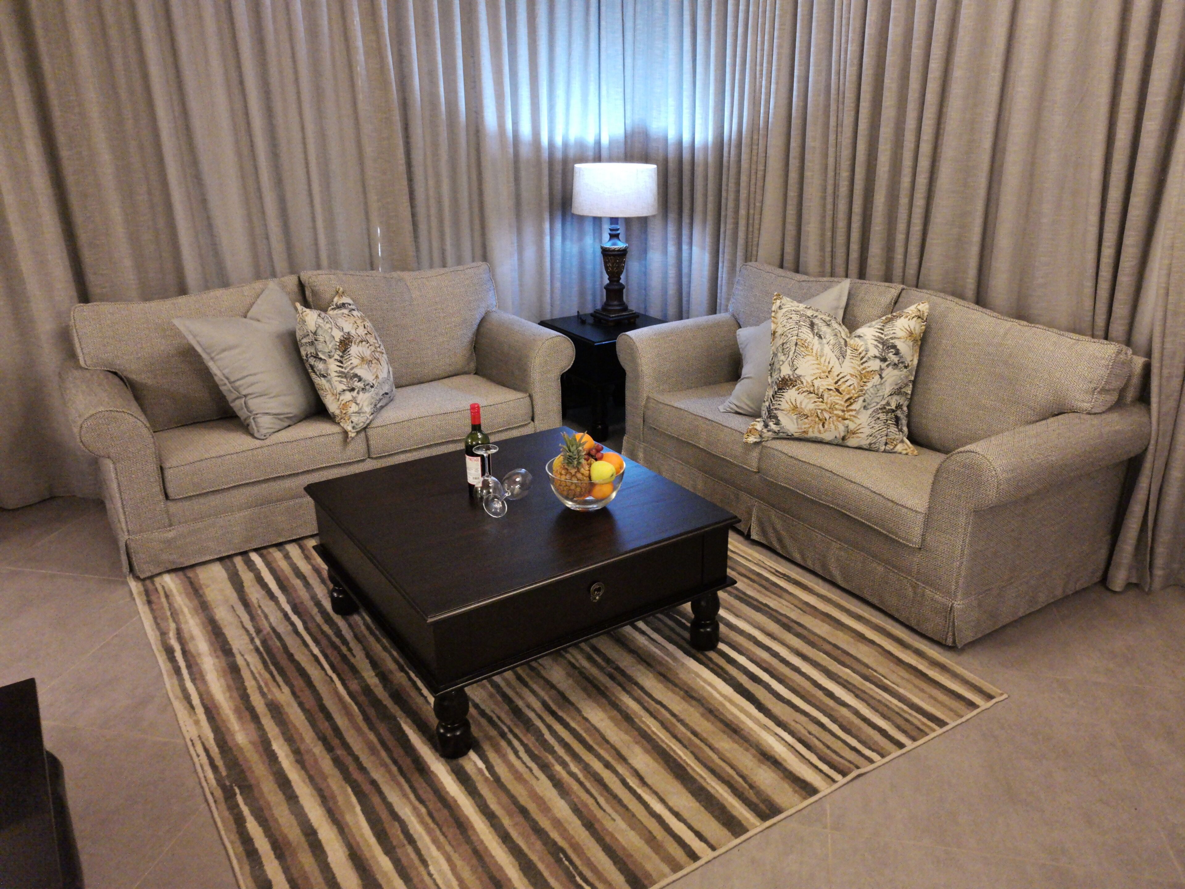 A living room with two sofas, a coffee table, and a lamp.