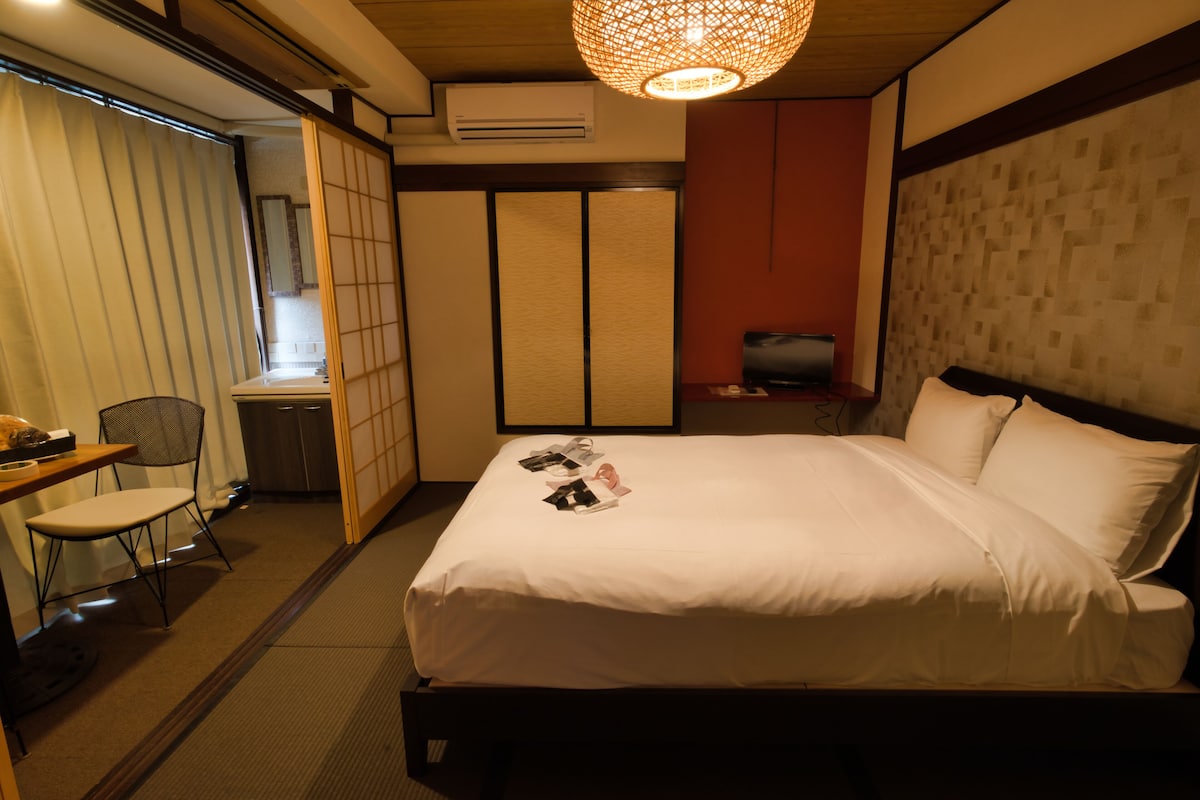 Een hotelkamer met een bed, een bureau, een stoel en een televisie.