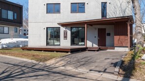 A modern building with a flat roof, large windows, and a covered entrance area. - Yuki Ten by H2 Life (Kutchan)