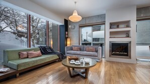 Un salon moderne avec un canapé, une table basse et une cheminée.