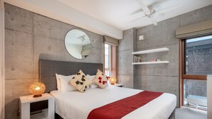 A modern bedroom with a large bed, a round mirror, a ceiling fan, and a window with a view of the outside. - Kitanishi 3 by H2 Life (Kutchan)