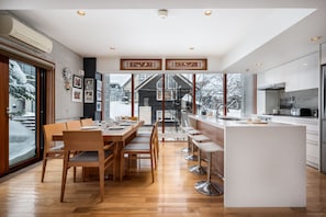 Una cocina moderna con una isla central, mesa de comedor de madera y sillas.