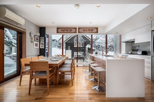 Una cocina moderna con una isla central, mesa de comedor de madera y sillas.