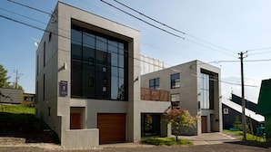Um edifício moderno de dois andares com grandes janelas e uma garagem.