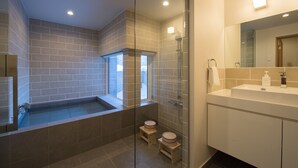 Ein modernes Badezimmer mit einer Duschkabine, einer Badewanne und einem Waschtisch mit Spiegel.