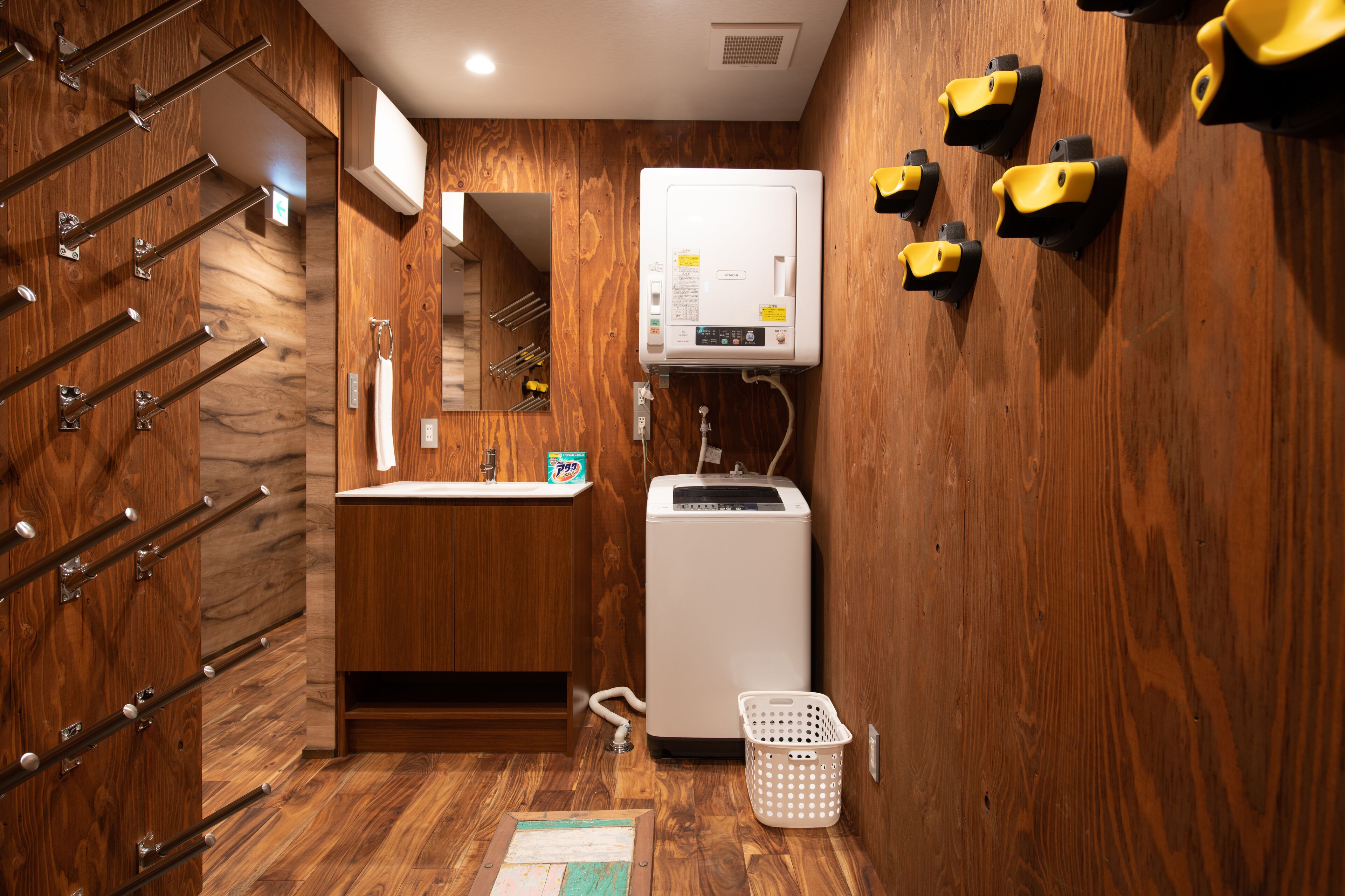 Un baño con detalles de madera, un lavabo integrado, un calentador blanco y un espejo.
