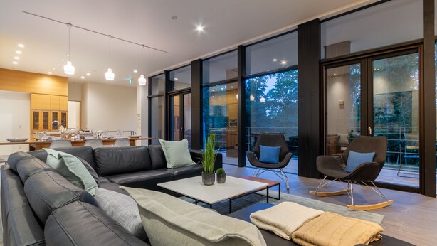 A modern living room with a sectional sofa, a coffee table, and two rocking chairs.