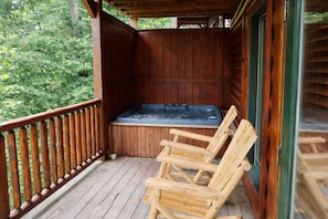 A wooden deck with a hot tub and wooden chairs. - All the amenities you need for R&R and/or fun, can sleep 18, Game Room. (gatlinburg)