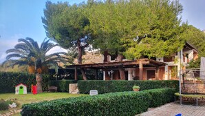 A well-maintained garden with a children's play area, a pergola, and a paved walkway. - VILLA PLEMMYRIA. Semi-detached villa immersed in the greenery of the Plemmirio Marine Protected Oasis (Plemmirio)