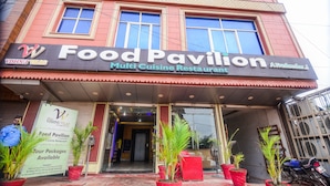 Un restaurante de cocina variada llamado 'Food Pavilion' con un letrero que anuncia paquetes turísticos.