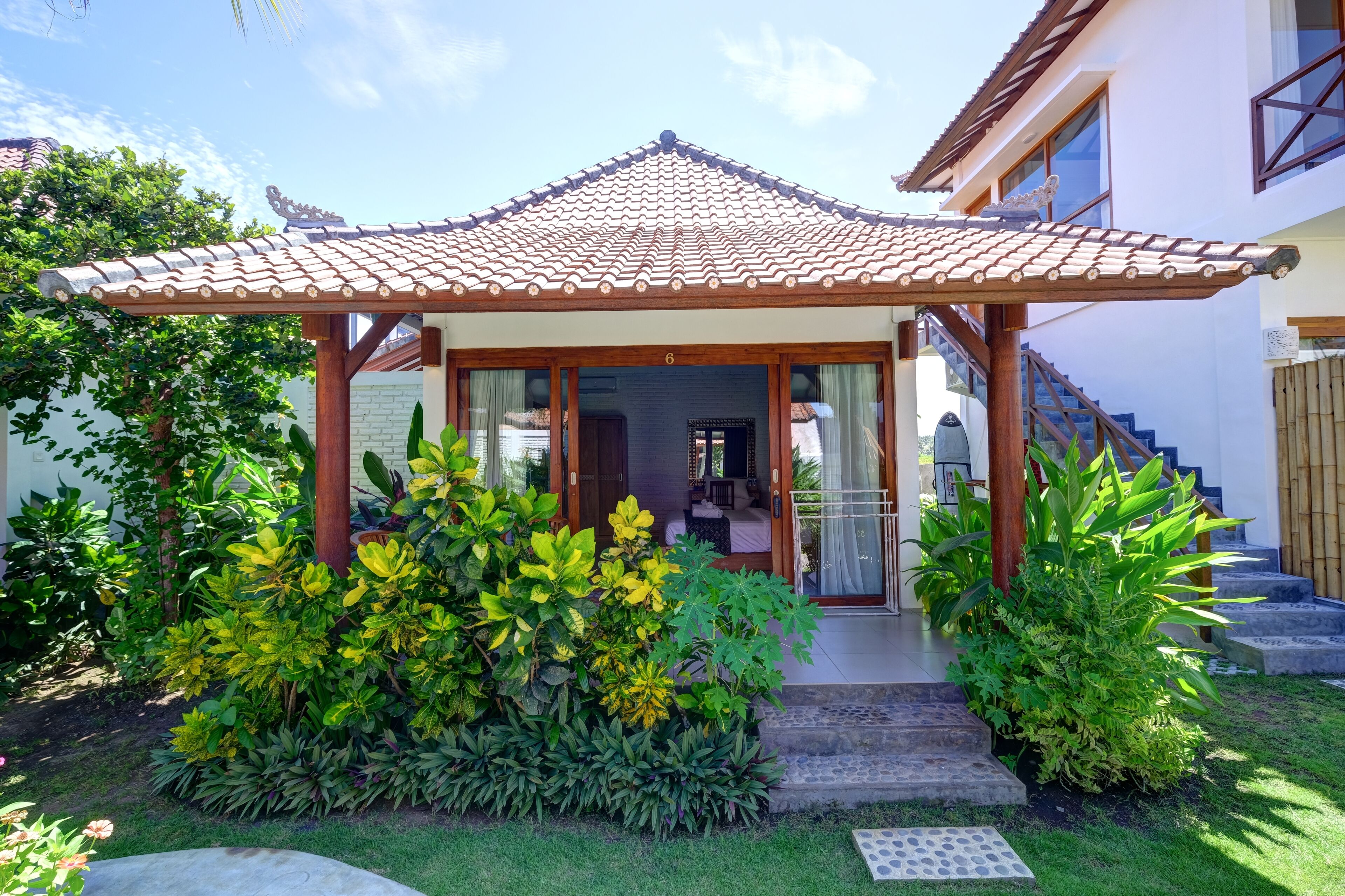Una casa de estilo tradicional con techo de tejas, un porche cubierto y una escalera que conduce a la entrada.