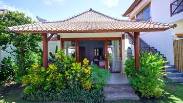 Una casa de estilo tradicional con techo de tejas, un porche cubierto y una escalera que conduce a la entrada.