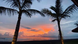 A sunset view with palm trees and a beach. - Wide Sands Beach Retreat (Mendoyo)