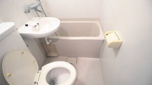 A small, white bathroom with a toilet, sink, and bathtub. - Narimasu Apartment 21 (Tokyo)