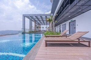 A rooftop infinity pool with lounge chairs and a pergola structure. - OYO Home 89854 Amazing Bukit Jalil (Kuala Lumpur)