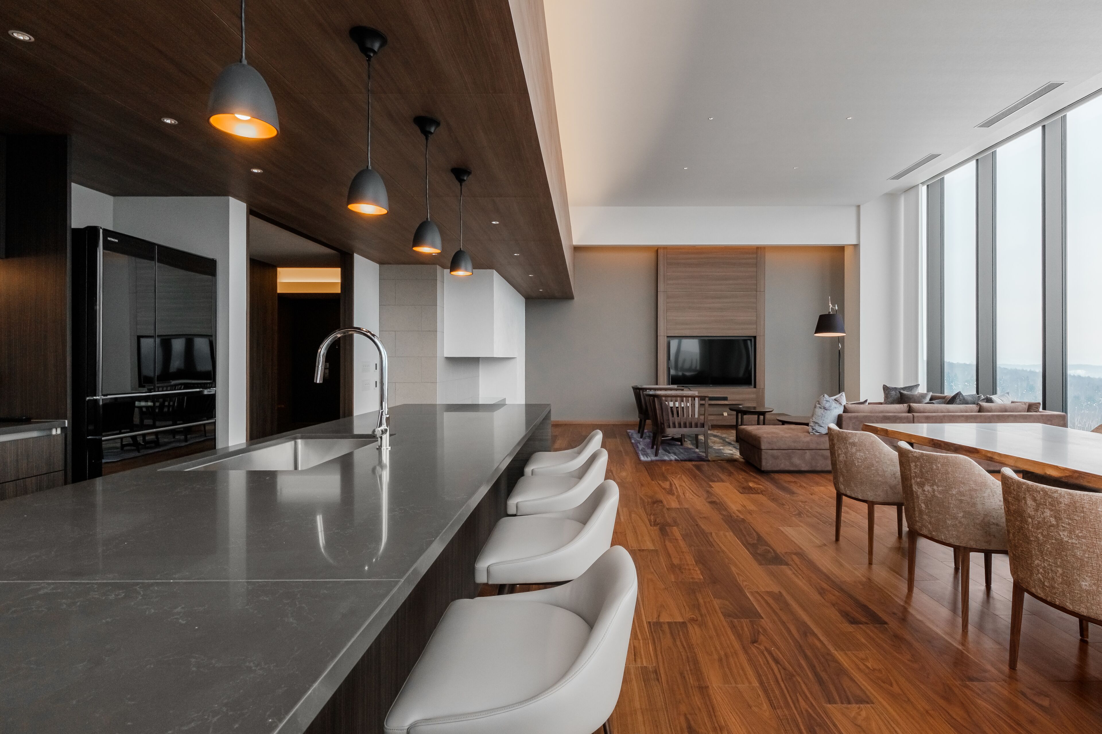 A modern kitchen with a central island, built-in appliances, and pendant lighting.