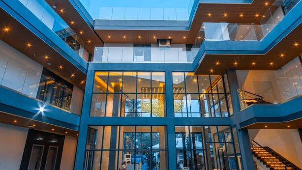 A multi-level atrium with glass railings and a central open space. - Begonia Resort (Panglao)