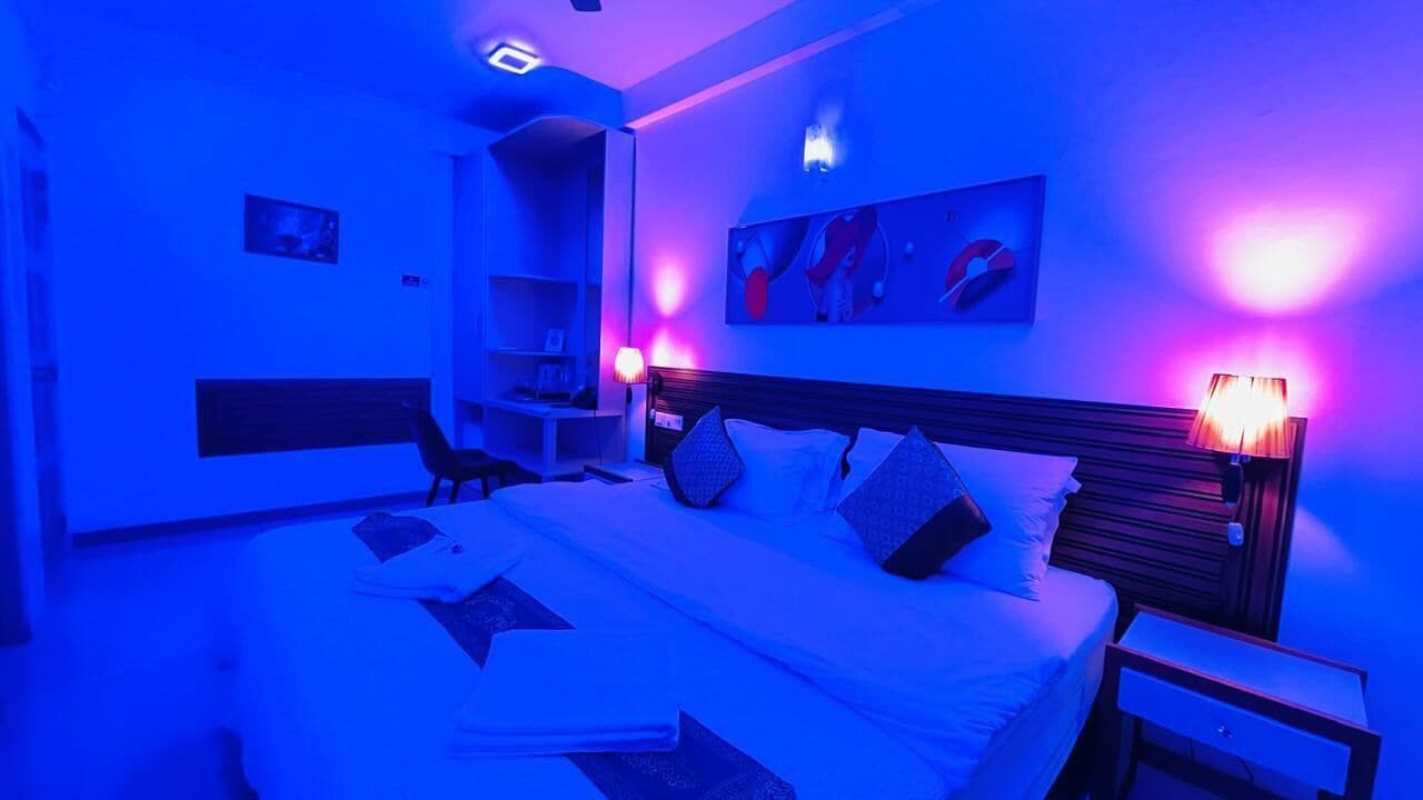 Un dormitorio con una cama, mesitas de noche, un escritorio y una silla.