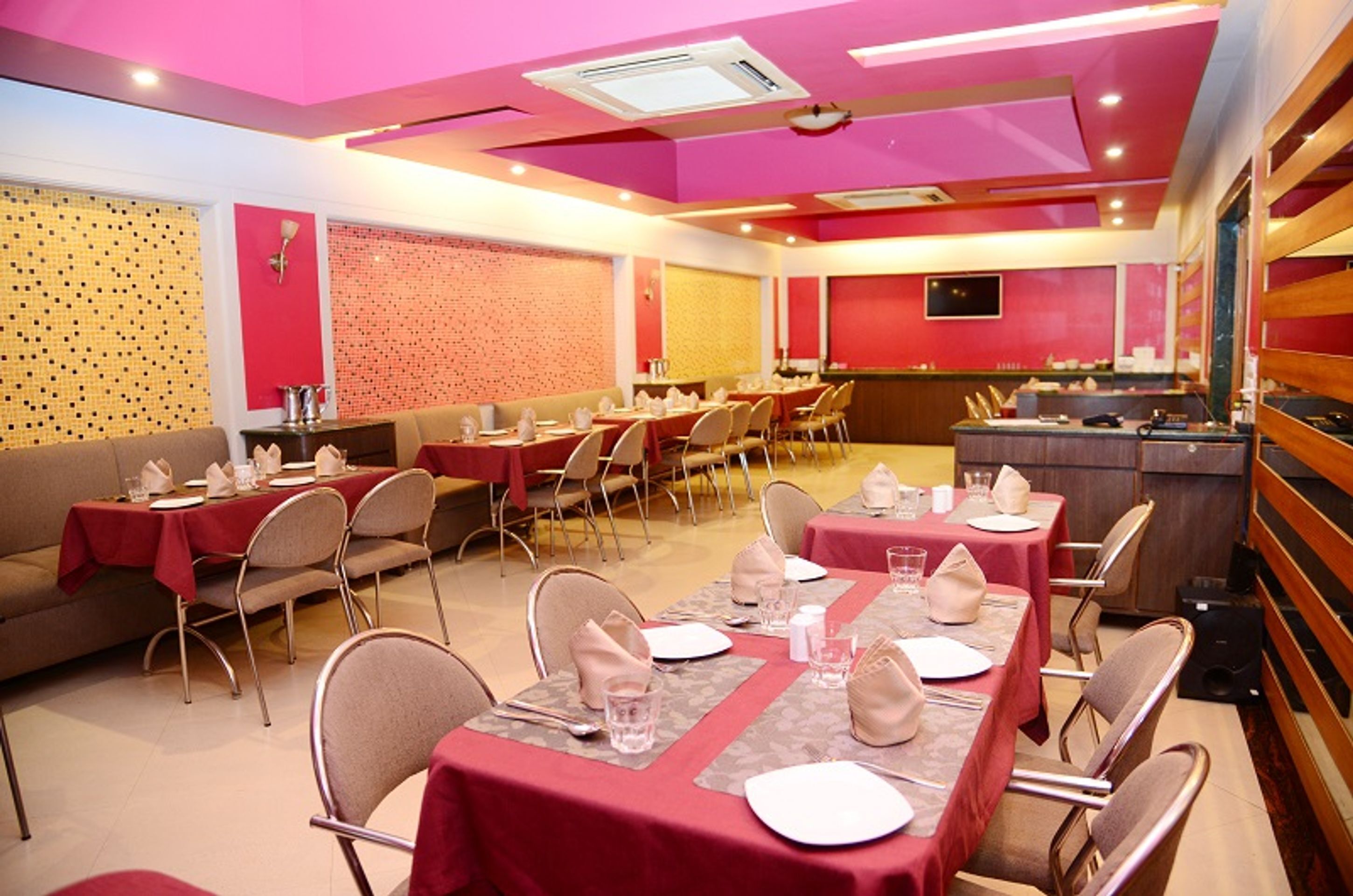 A restaurant with multiple tables set for dining, each with chairs and table settings.