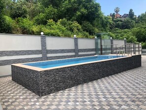 季节性开放的室外游泳池，池畔遮阳伞，日光浴躺椅