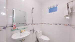 A bathroom with a white sink, toilet, and shower. There is a mirror above the sink, a small window, and a towel rack. - OYO 898 Phuong Thao Hotel (Nha Trang)