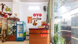 A reception desk with a sign indicating 'Reception' and operating hours. - OYO 898 Phuong Thao Hotel (Nha Trang)
