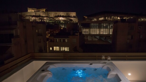 A hot tub with ice, a view of buildings, and a balcony railing. - Acropolis Golden Suites by GHH (Athens)