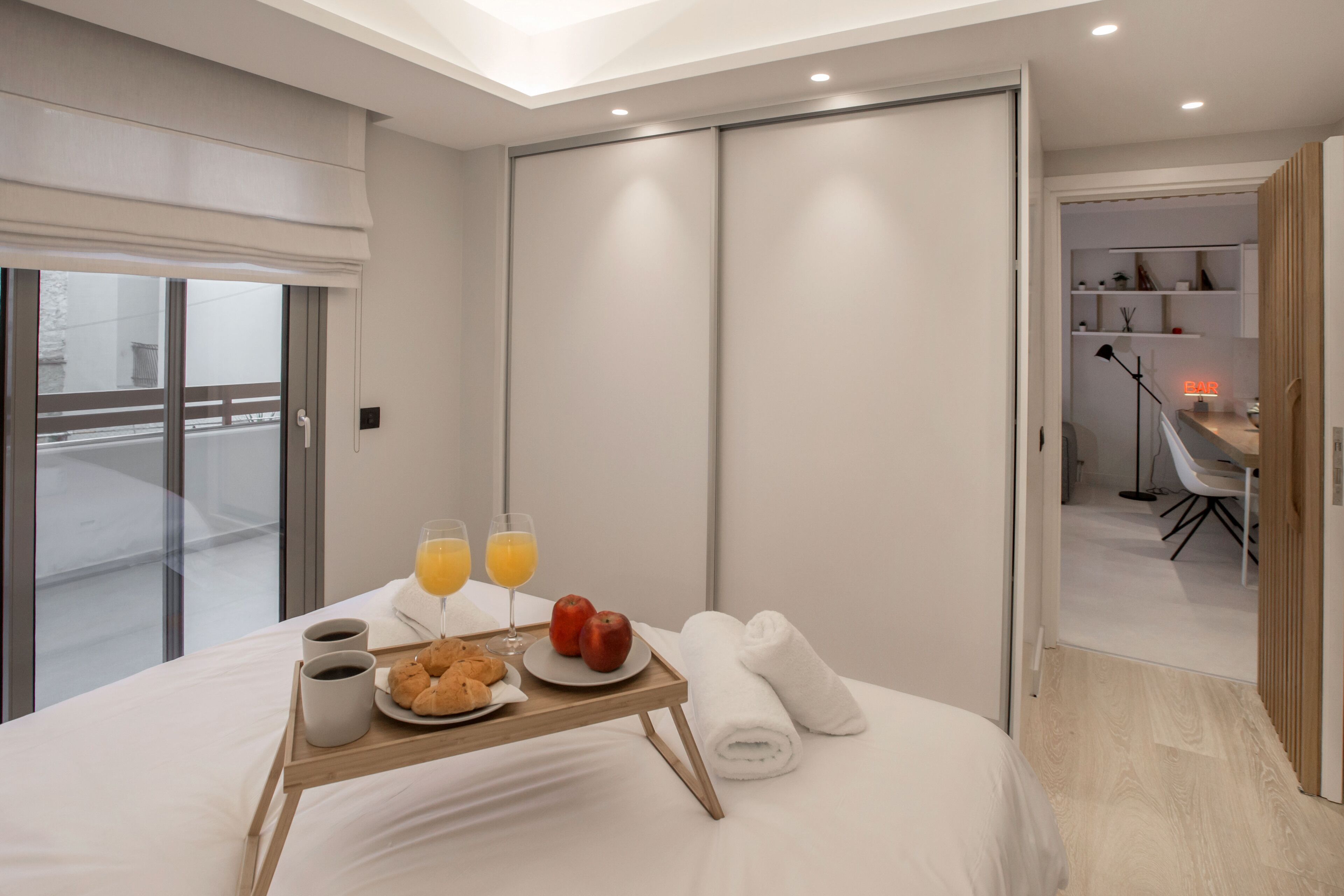 Une chambre d’hôtel avec un lit, un plateau de petit-déjeuner et un espace bureau.