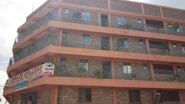 Un edificio de varios pisos con un letrero que indica Jubilee College y Pretoria Hotel.