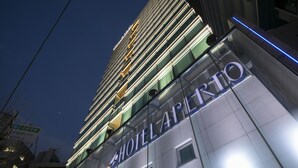 Un hôtel doté d’une façade moderne, d’une enseigne lumineuse et offrant une vue dégagée sur le ciel.