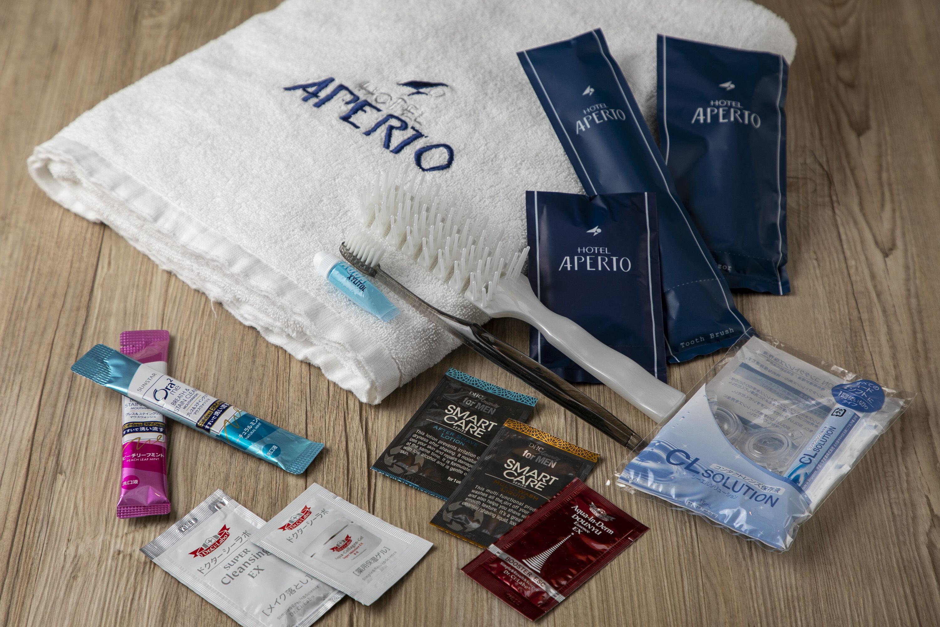 A hotel room with a white towel, toiletries, and a toothbrush.