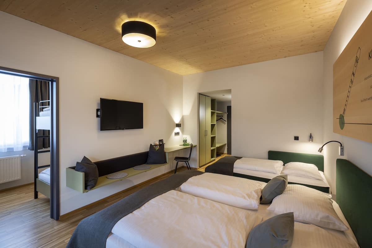 Een moderne hotelkamer met twee bedden, een bureau, een stoel en een televisie.
