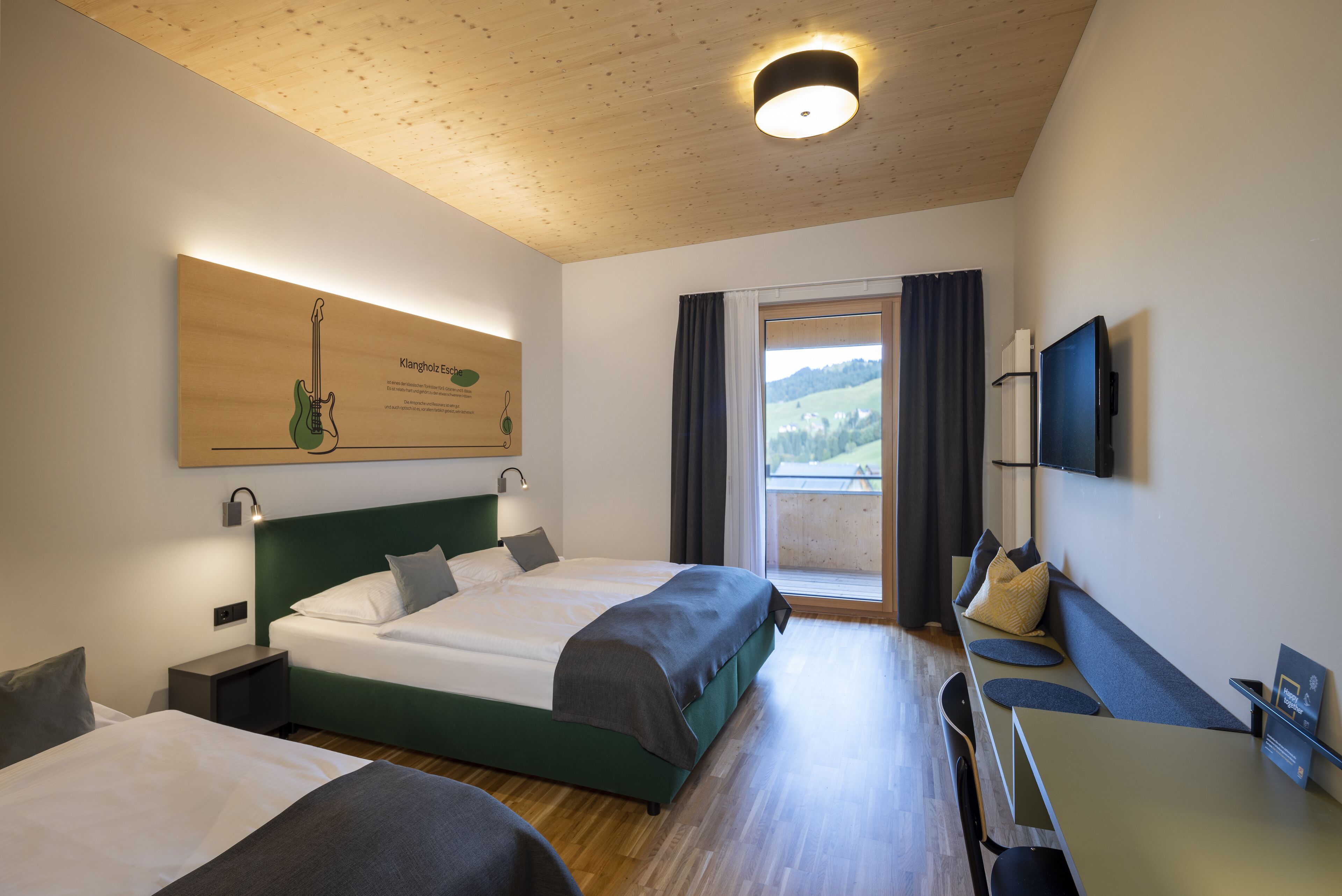 Una habitación de hotel moderna con dos camas, un escritorio y un televisor.