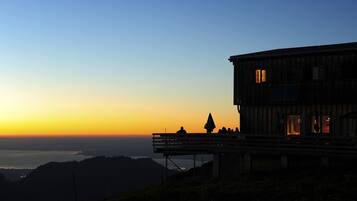 A wooden building with a balcony overlooking a scenic view.