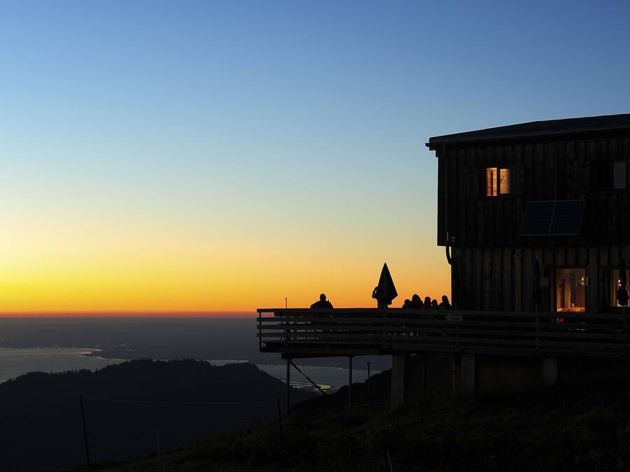A wooden building with a balcony overlooking a scenic view.