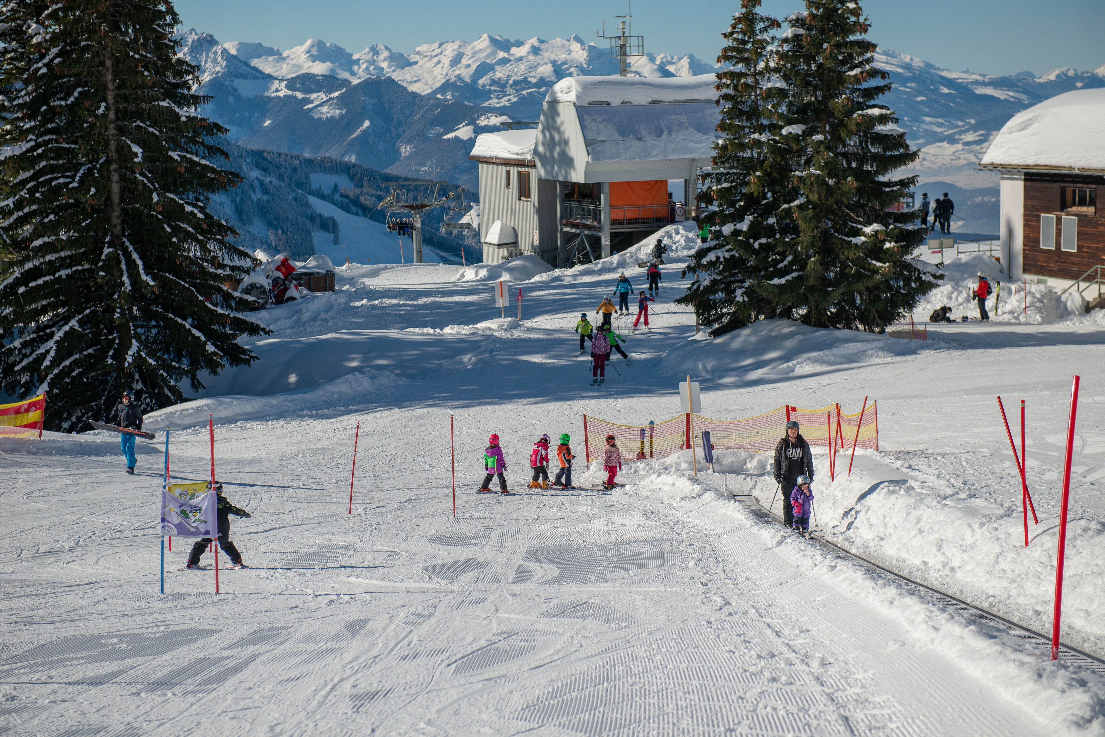 A ski resort with snow-covered slopes, a ski lift, and a lodge with a snow-covered roof.