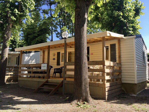 Un hilera de casas móviles con terrazas de madera y un letrero que indica 'Grenco's'.