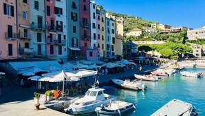 Uma marina com edifícios coloridos, barcos e áreas de estar ao ar livre.