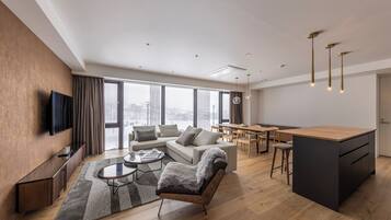 A modern living room with a sofa, coffee table, and a TV mounted on the wall.