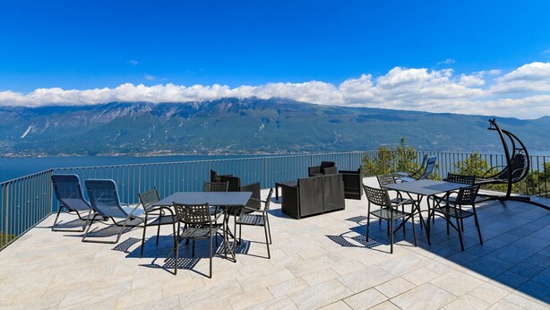 A terrace with outdoor furniture, a view of a lake, and mountains in the background. - Albicocca: lake view, nature and relax (Tignale)