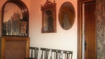 A room with a wooden bench, a mirror, and a door.
